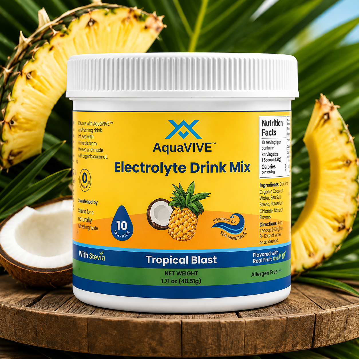 A tub of AquaVIVE Electrolyte Drink Mix in Tropical Blast flavor, styled on a wooden surface with sliced pineapples and a coconut half in the background.